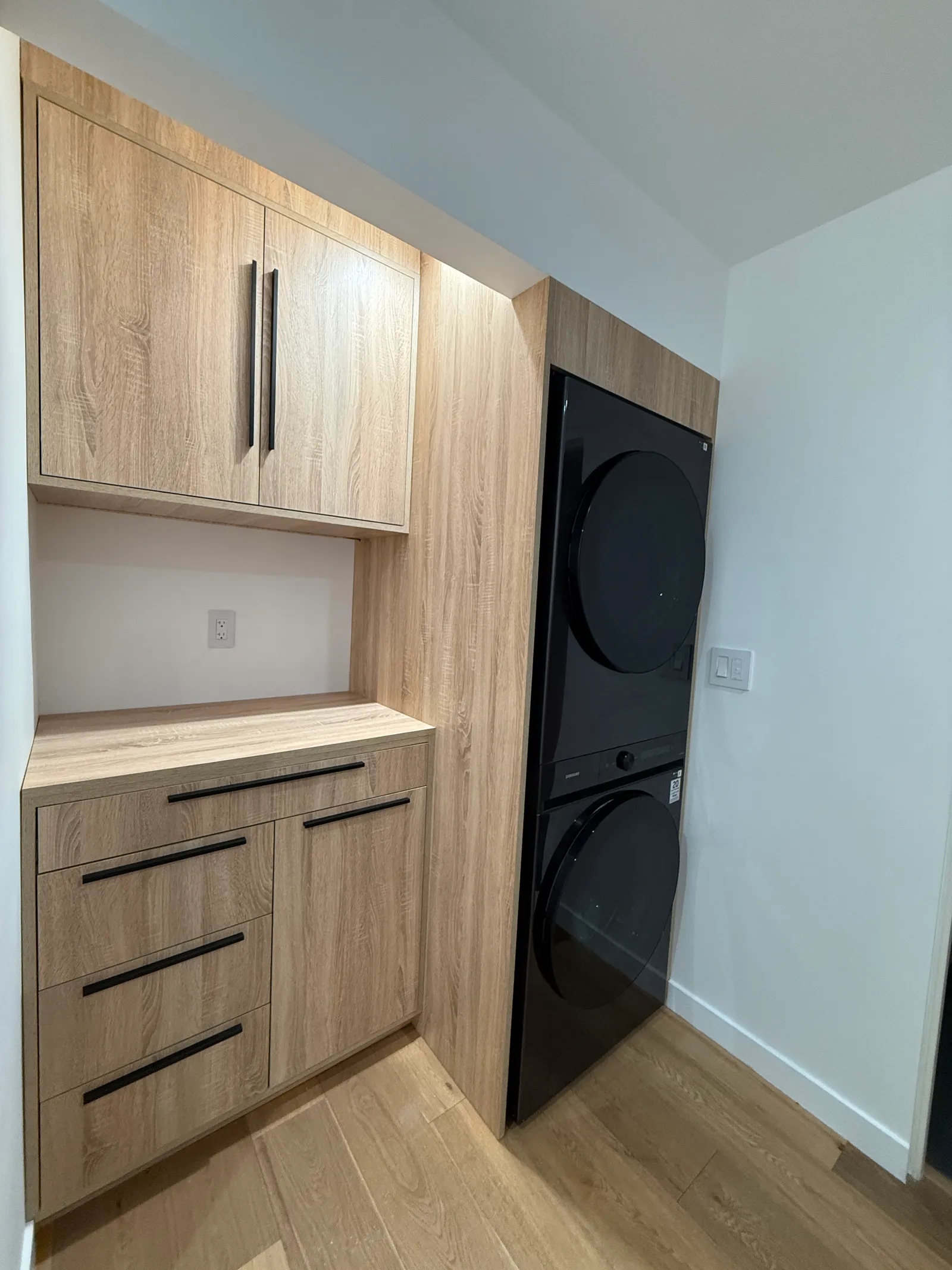 Built-in laundry cabinetry framing a stacked washer and dryer in a La Crescenta home
