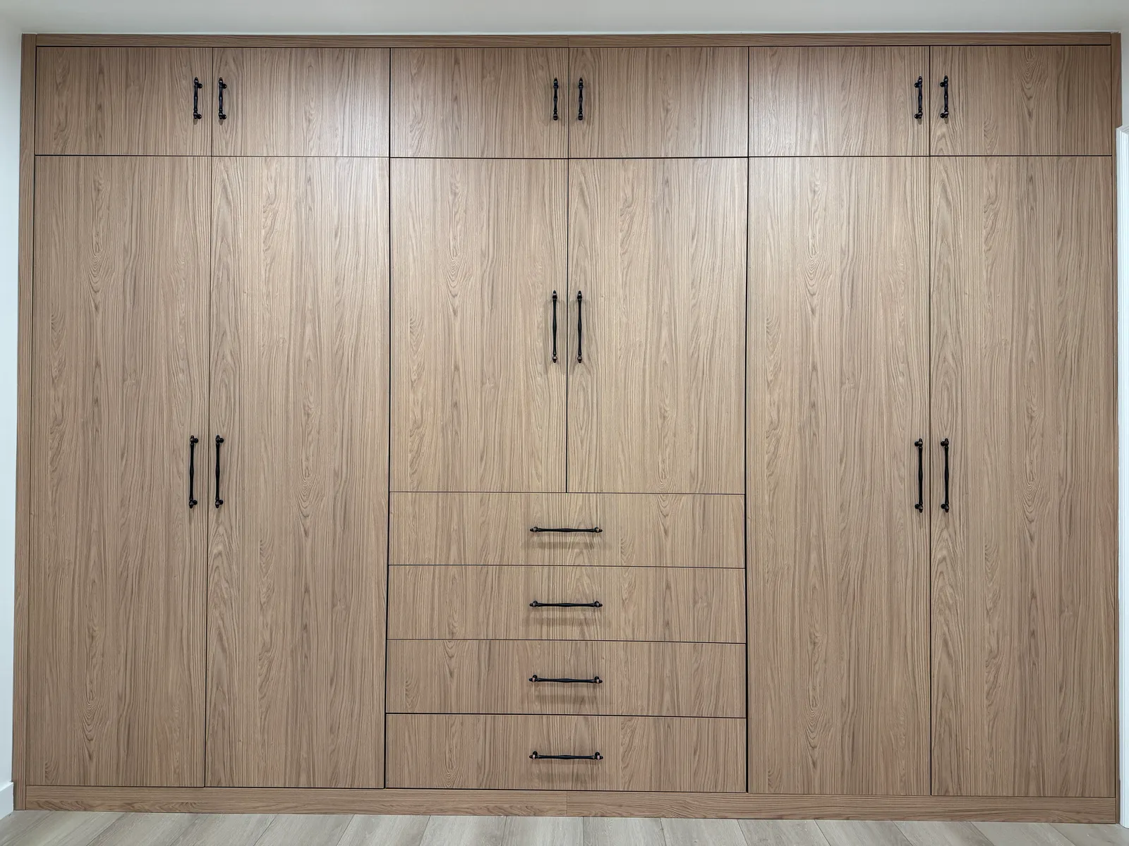 Built-in wardrobe with central drawers and tall storage cabinets