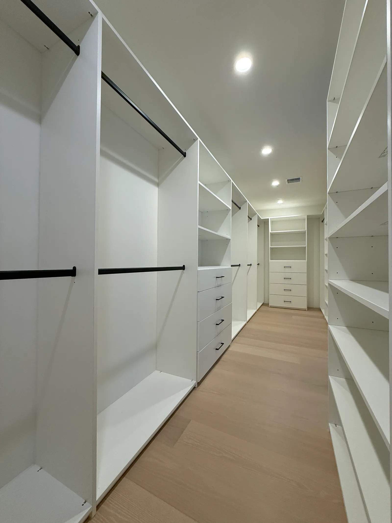 Long walk-in closet layout with white melamine cabinetry in Sun Valley