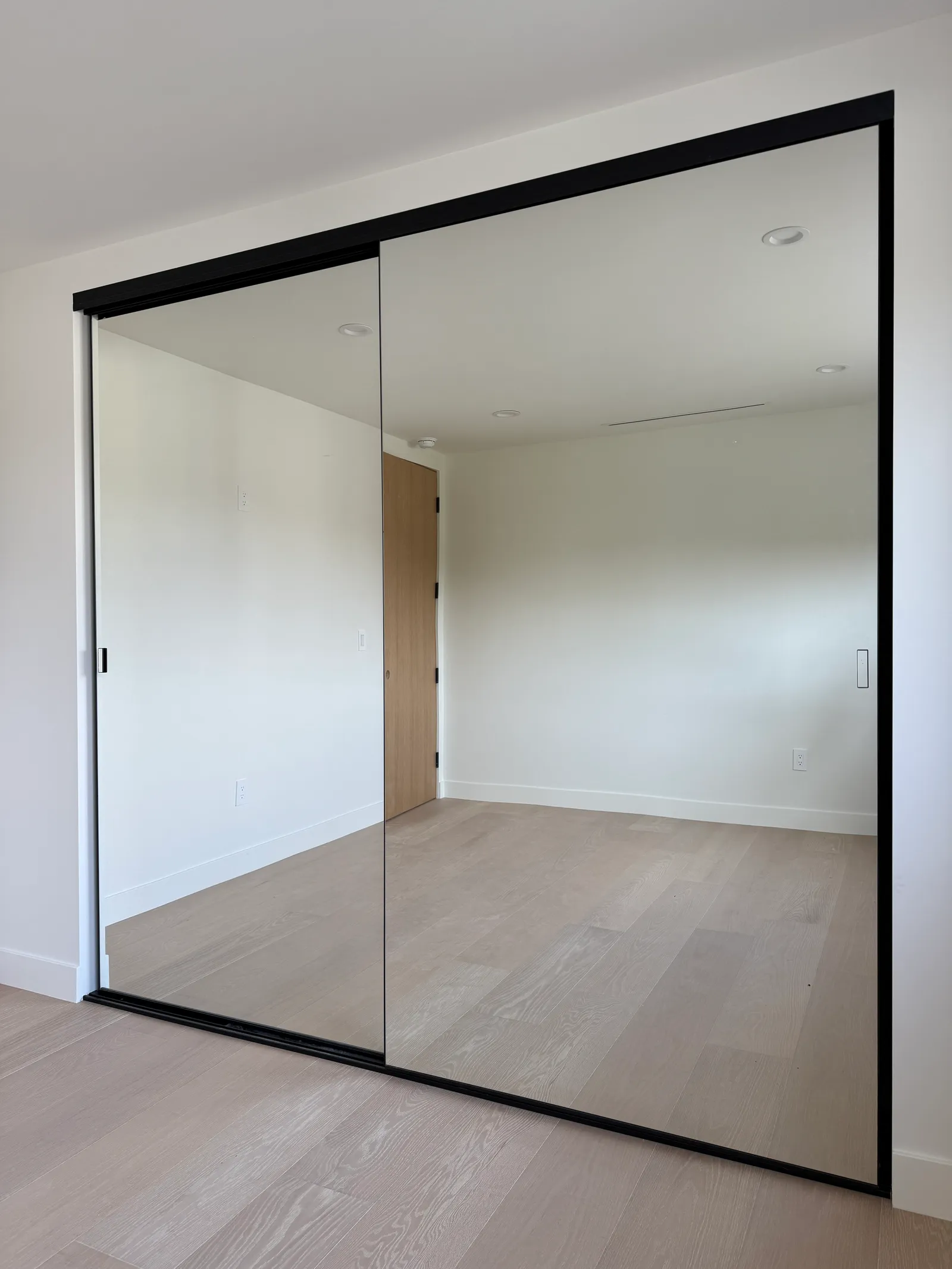 Custom mirrored sliding closet doors on a black aluminum track in Sun Valley