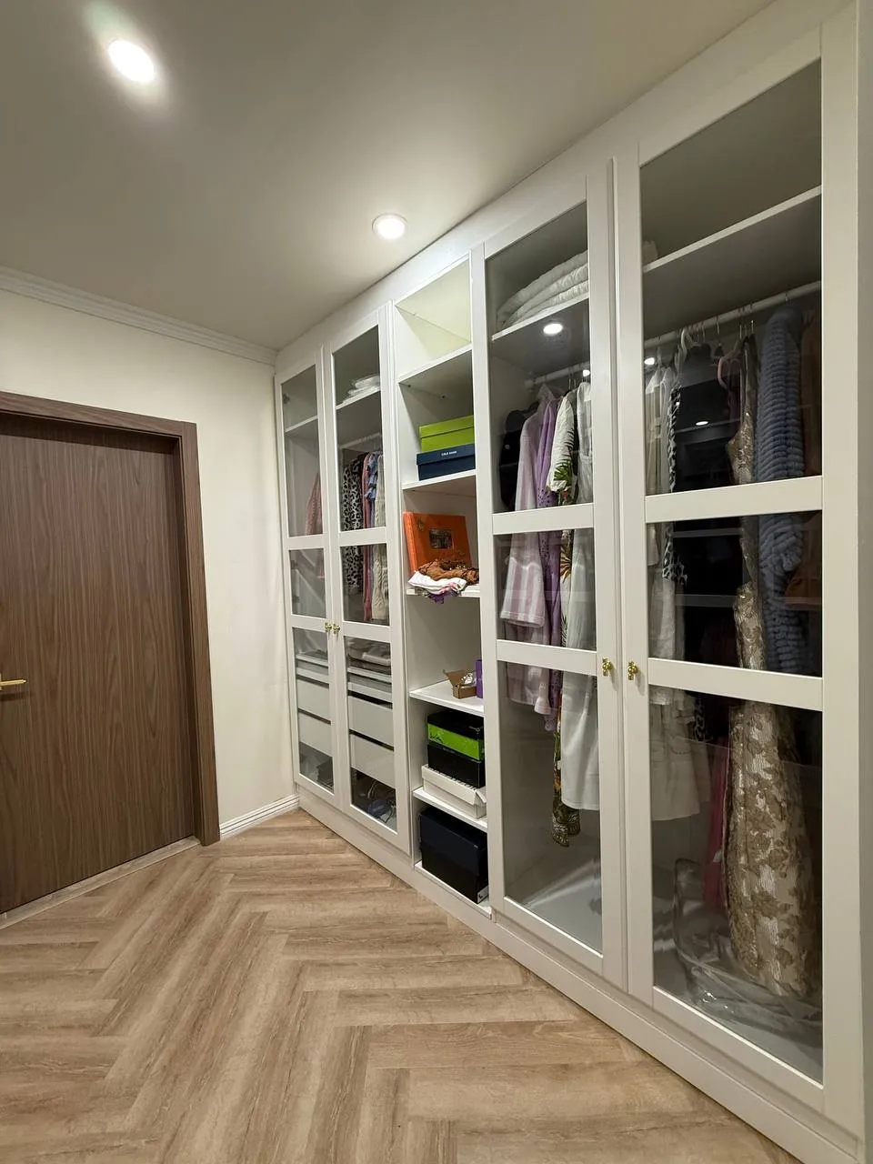 Custom white wall unit with glass-front doors and built-in storage in Van Nuys