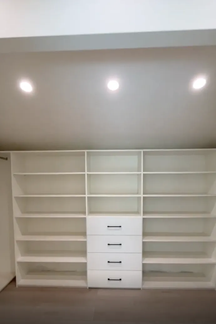 White melamine walk-in closet with central drawers and open shelving in Lake Balboa