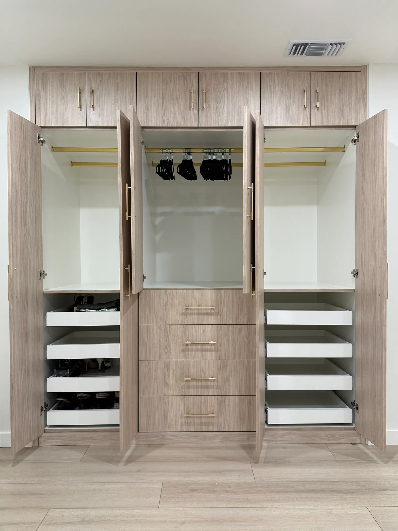 Custom wardrobe interior with hanging rods, shelving and built-in drawers in Tujunga