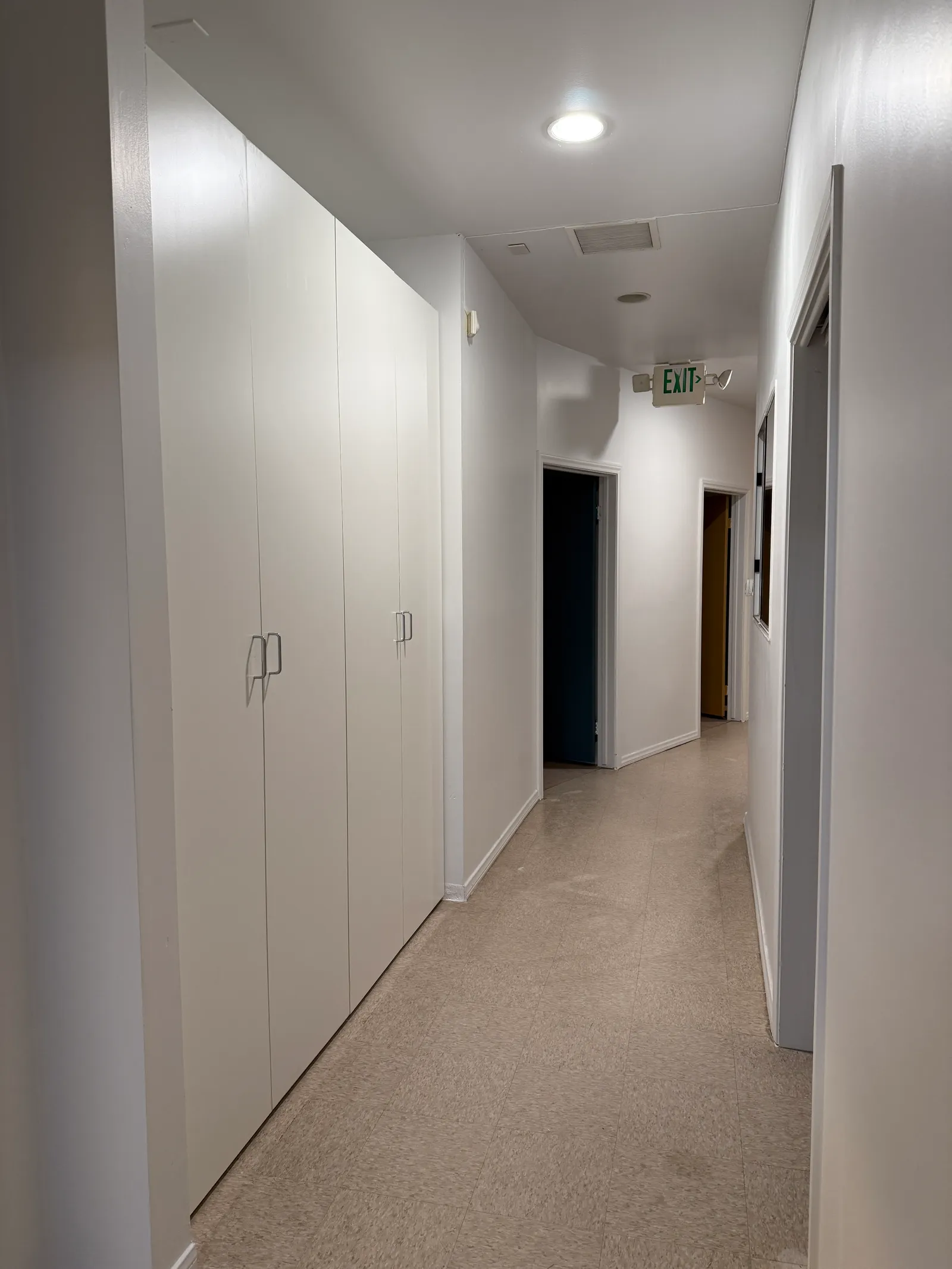 Custom hallway storage cabinets with white melamine doors in Glendale