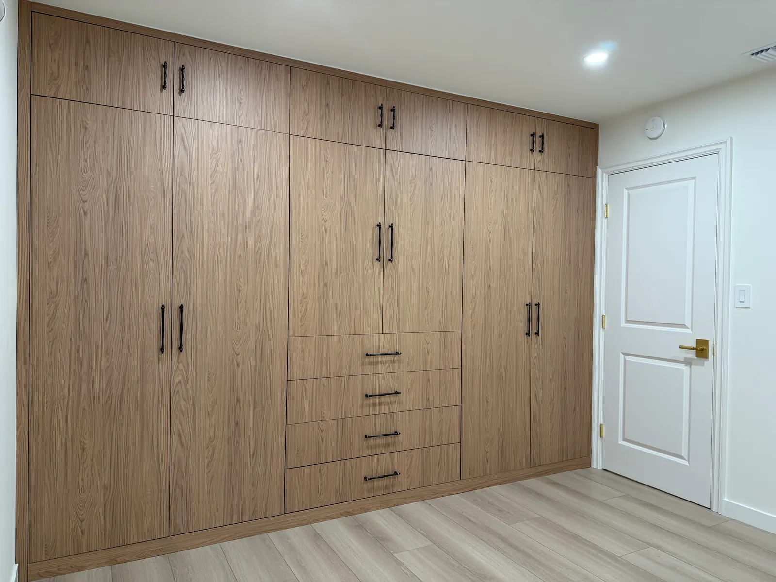 Custom full-wall wardrobe with wood-look melamine cabinetry in Tujunga