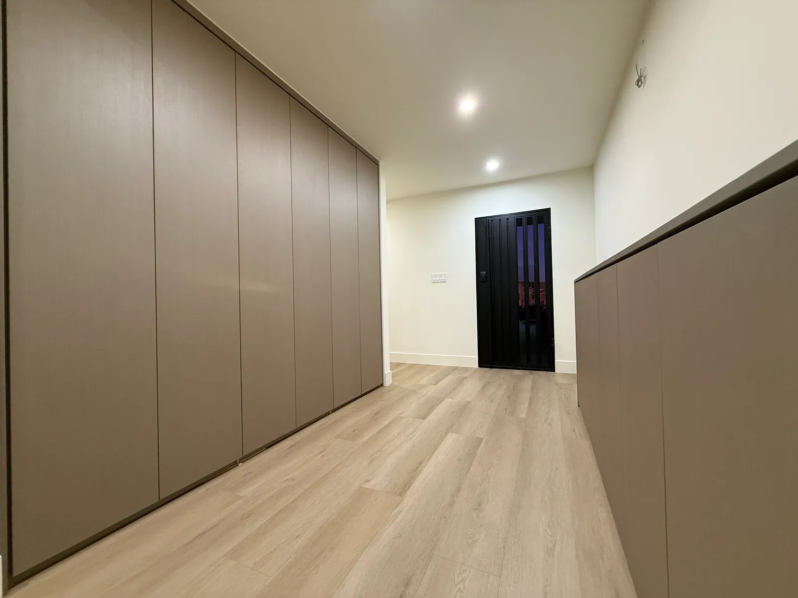 Custom hallway with full-height and low-profile built-in storage units