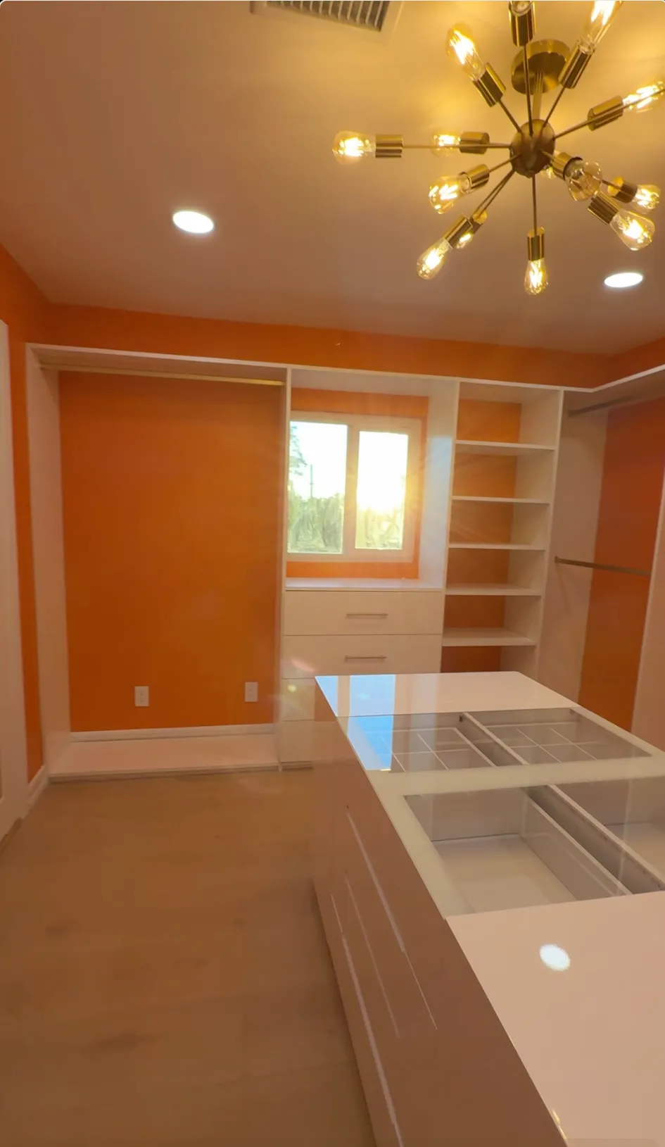 Custom walk-in closet with white melamine shelving and built-in drawers in North Hollywood