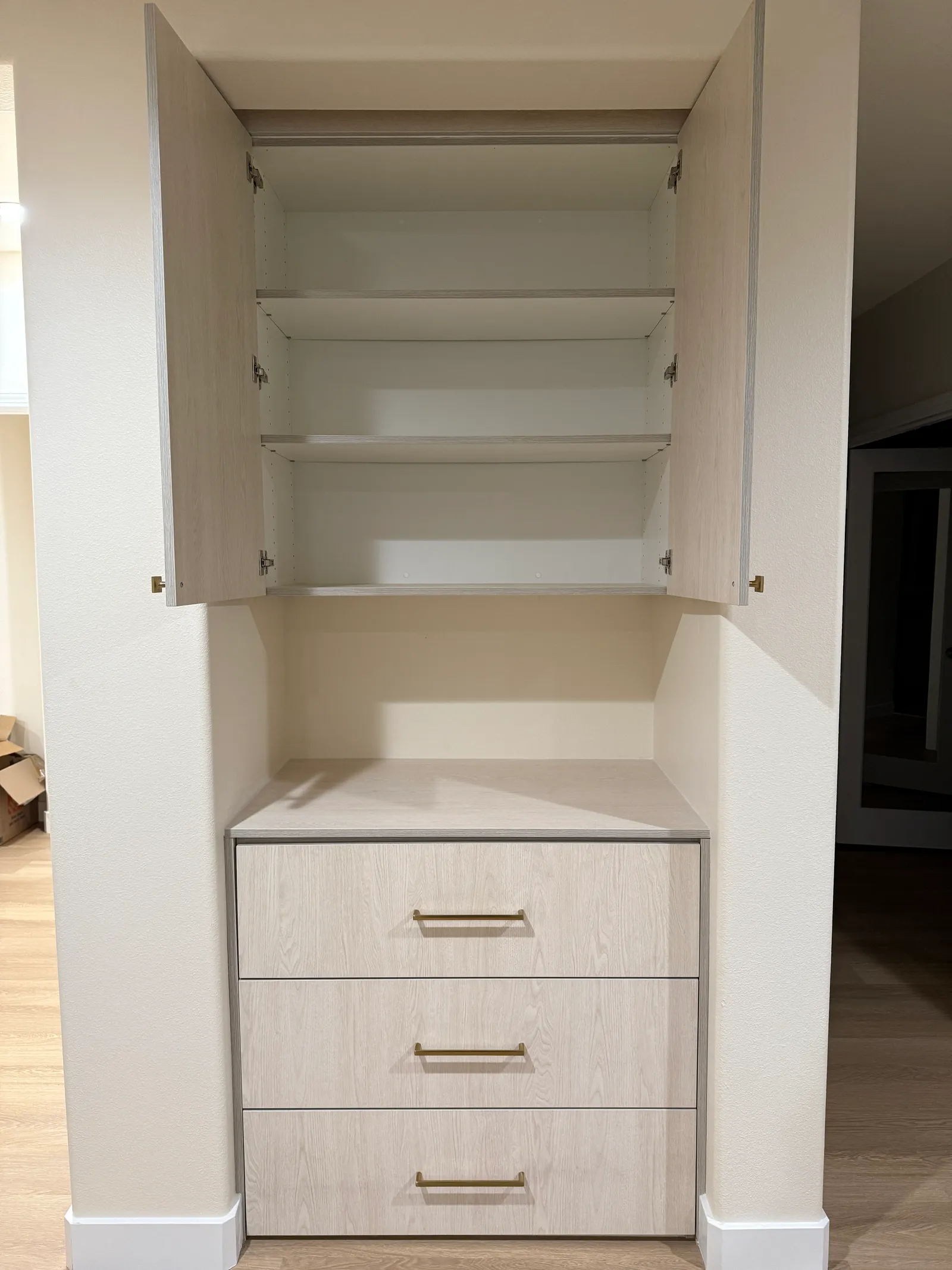Custom wall unit with open upper cabinet shelving and built-in drawers in Sun Valley