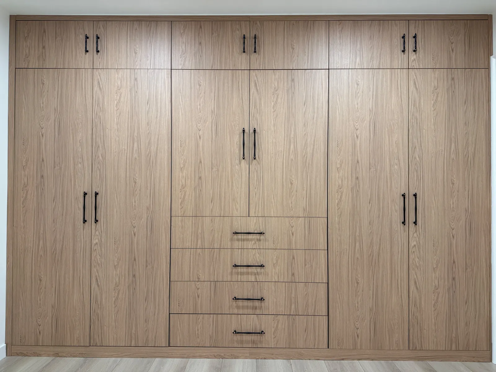 Custom full-wall wardrobe with wood-look melamine cabinetry in Tujunga