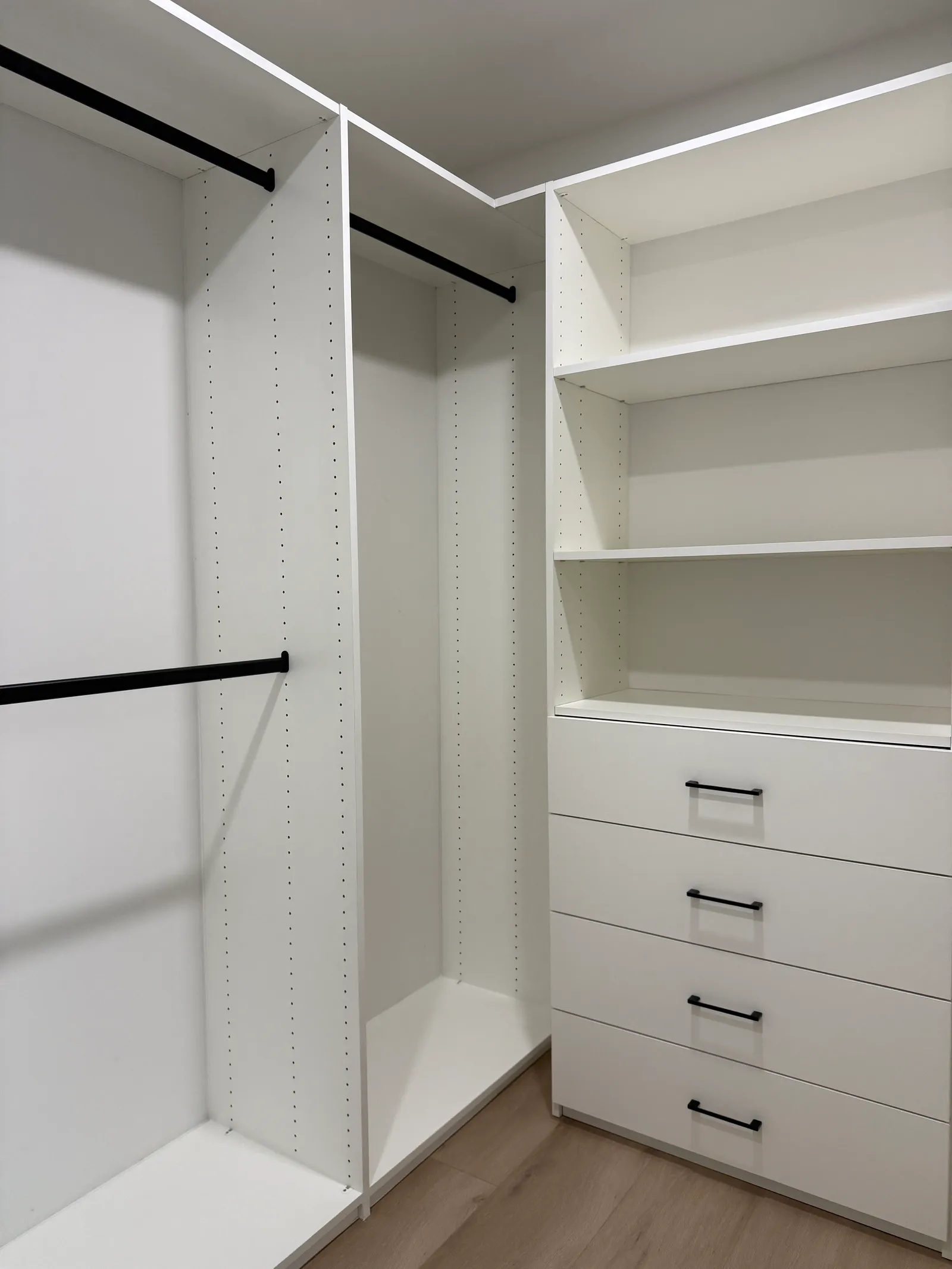 Custom walk-in closet with white melamine shelving and built-in drawers in North Hollywood