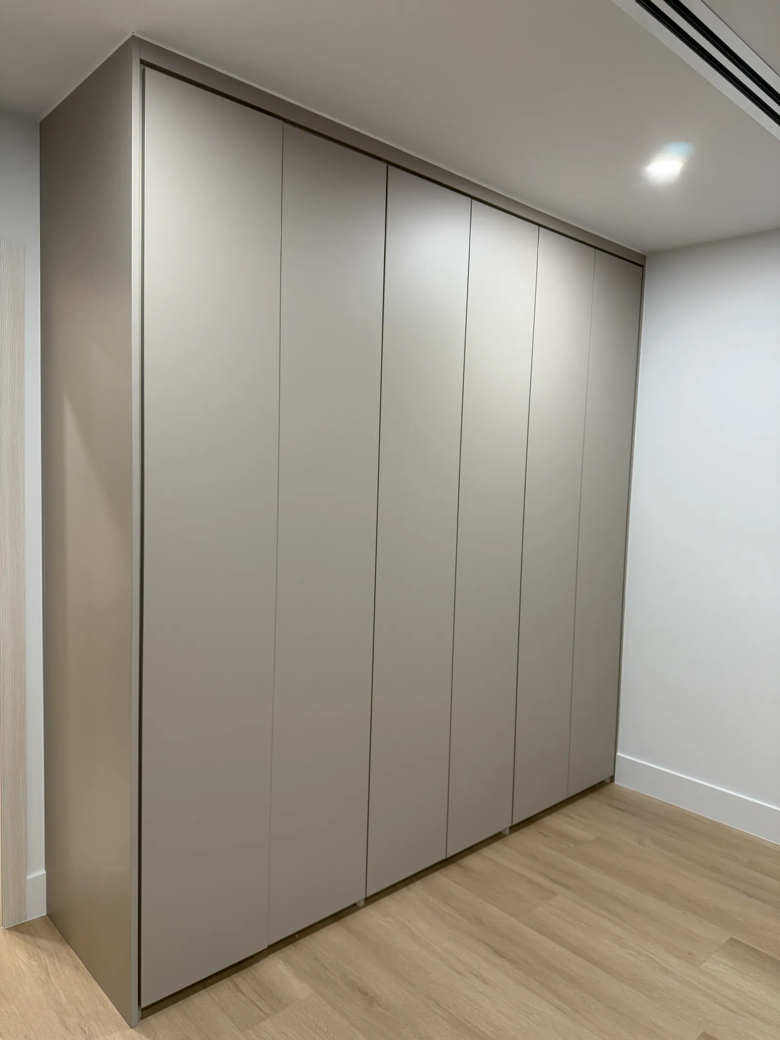 Detail of matte melamine push-to-open wardrobe doors