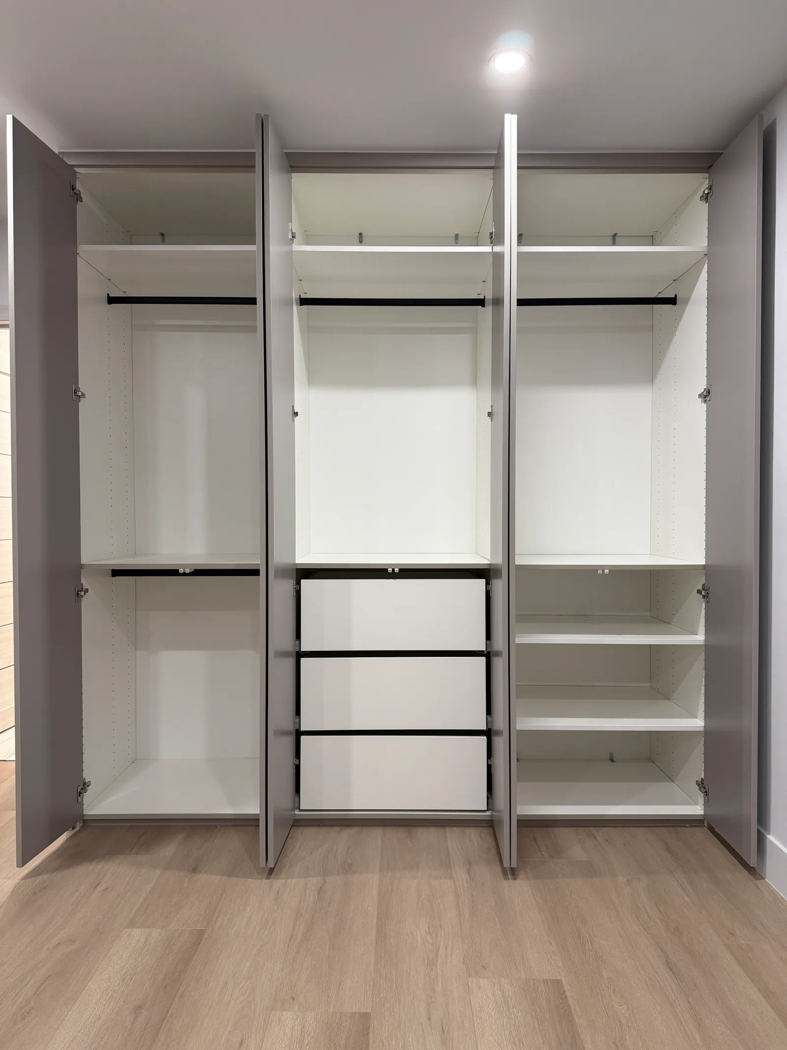 Bedroom wardrobe interior with hanging rods, drawers, and shelving