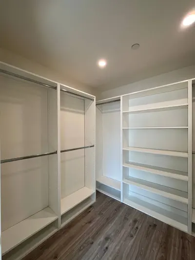 White melamine walk-in closet with hanging sections and open shelving
