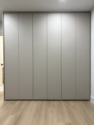 Full-height built-in bedroom wardrobe with handle-free doors