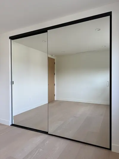 Custom mirrored sliding closet doors on a black aluminum track in Sun Valley