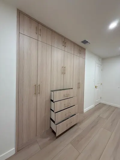 Full-height wardrobe with wood-look doors and built-in drawer storage