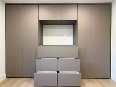 Custom bedroom wall unit with recessed niche and open drawer storage