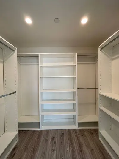 Custom walk-in closet with central shelving and hanging storage in Reseda