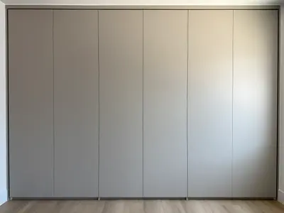 Handle-free built-in bedroom wardrobe with push-to-open doors
