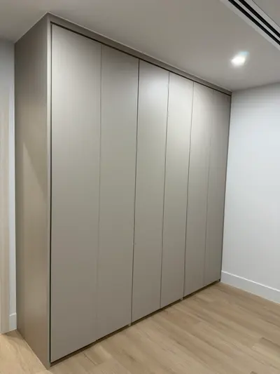 Detail of matte melamine push-to-open wardrobe doors