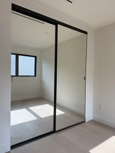 Black-framed mirrored closet doors in a second bedroom in Sun Valley