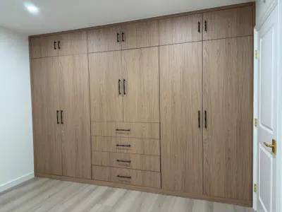 Built-in wardrobe with tall storage doors and central drawers in Tujunga